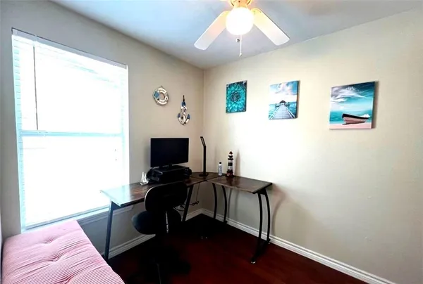 a view of a workspace with furniture and a window