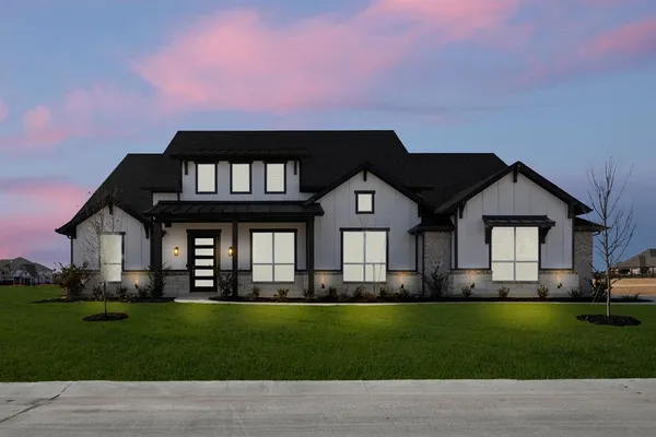 a front view of a house with a garden and yard