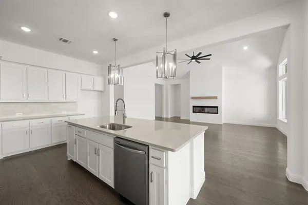 a kitchen that has a lot of cabinets and wooden floor