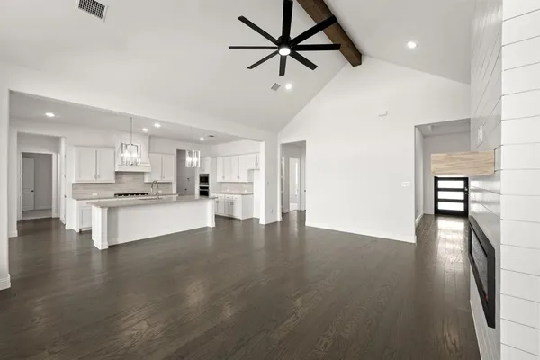 a view of kitchen with refrigerator stove and a wooden floor