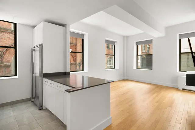 a kitchen with granite countertop a sink window and refrigerator