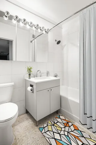 a bathroom with a sink mirror vanity and toilet