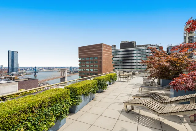 a view of a balcony with chairs and wooden fence