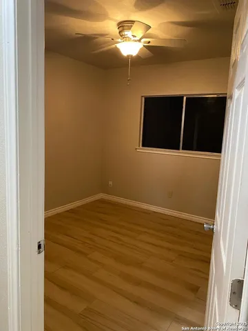 a view of empty room with window and ceiling fan