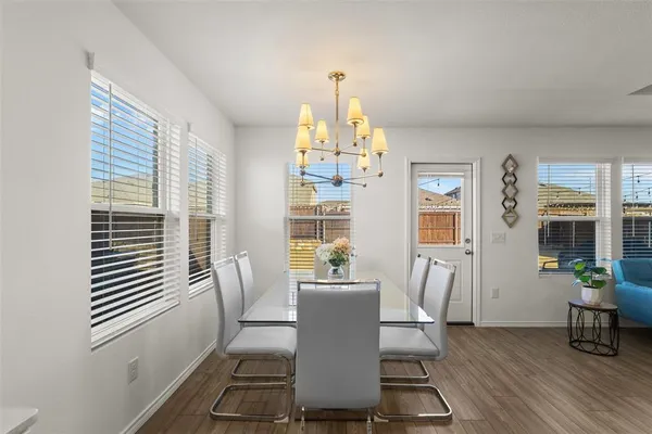 a dining room with wooden floor and a potted plant