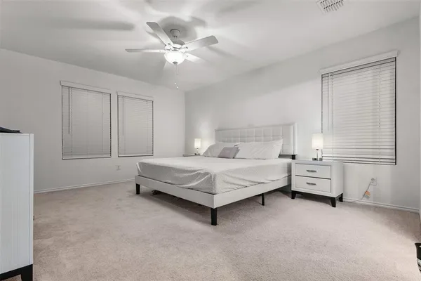 a spacious bedroom with a bed and a chandelier