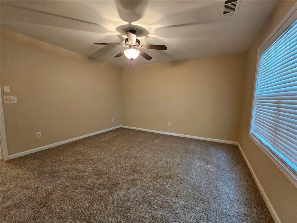 2160 Spikerush Way Buford, GA 30519 - Photo 21 of 29 an empty room with a window and a fan