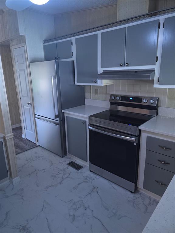 1705 Kiley Court The Villages, FL 32159 - Photo 2 of 20 a kitchen with a stove and a refrigerator with cabinets