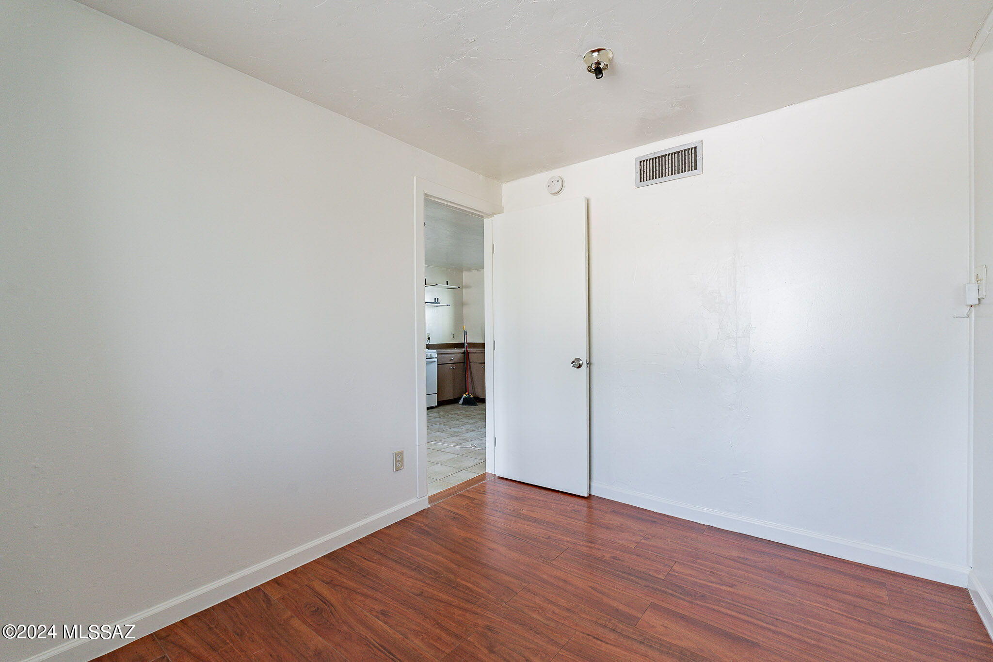 608 East Roger Road Tucson, AZ 85705 - Photo 12 of 13 a view of an empty room with wooden floor