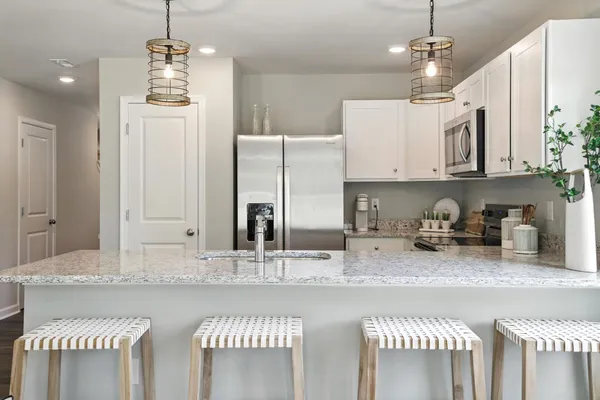 a kitchen with stainless steel appliances granite countertop a sink a stove and a refrigerator