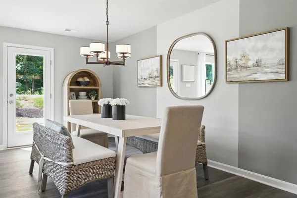 a dining room with furniture a potted plant and wooden floor