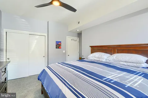 a bedroom with a bed and a chandelier fan