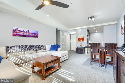 a living room with furniture gym equipment and a ceiling fan