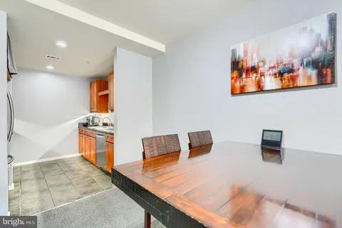 a living room with stainless steel appliances kitchen island granite countertop a refrigerator and a stove top oven