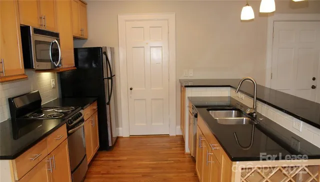 a kitchen with a refrigerator stove and wooden cabinets