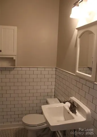 a bathroom with a sink a toilet and mirror