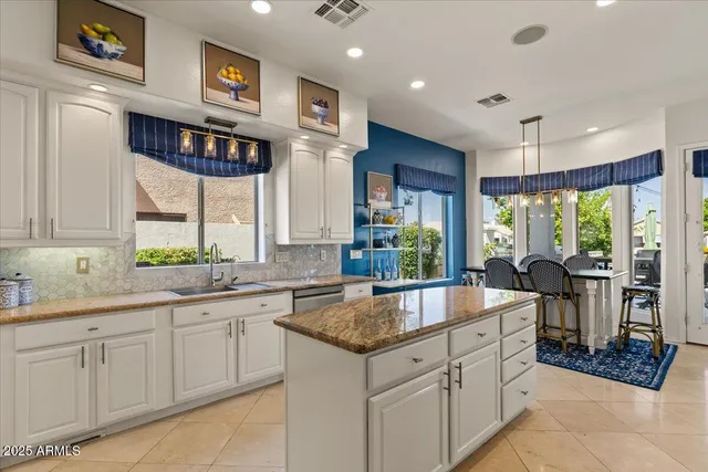 a large kitchen with stainless steel appliances kitchen island granite countertop a sink and cabinets