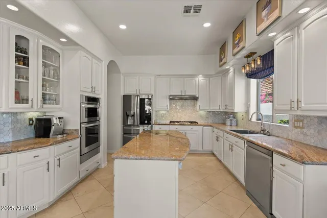 a kitchen with a sink refrigerator and cabinets