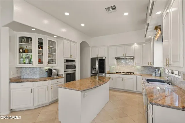 a kitchen with granite countertop a sink stainless steel appliances and cabinets