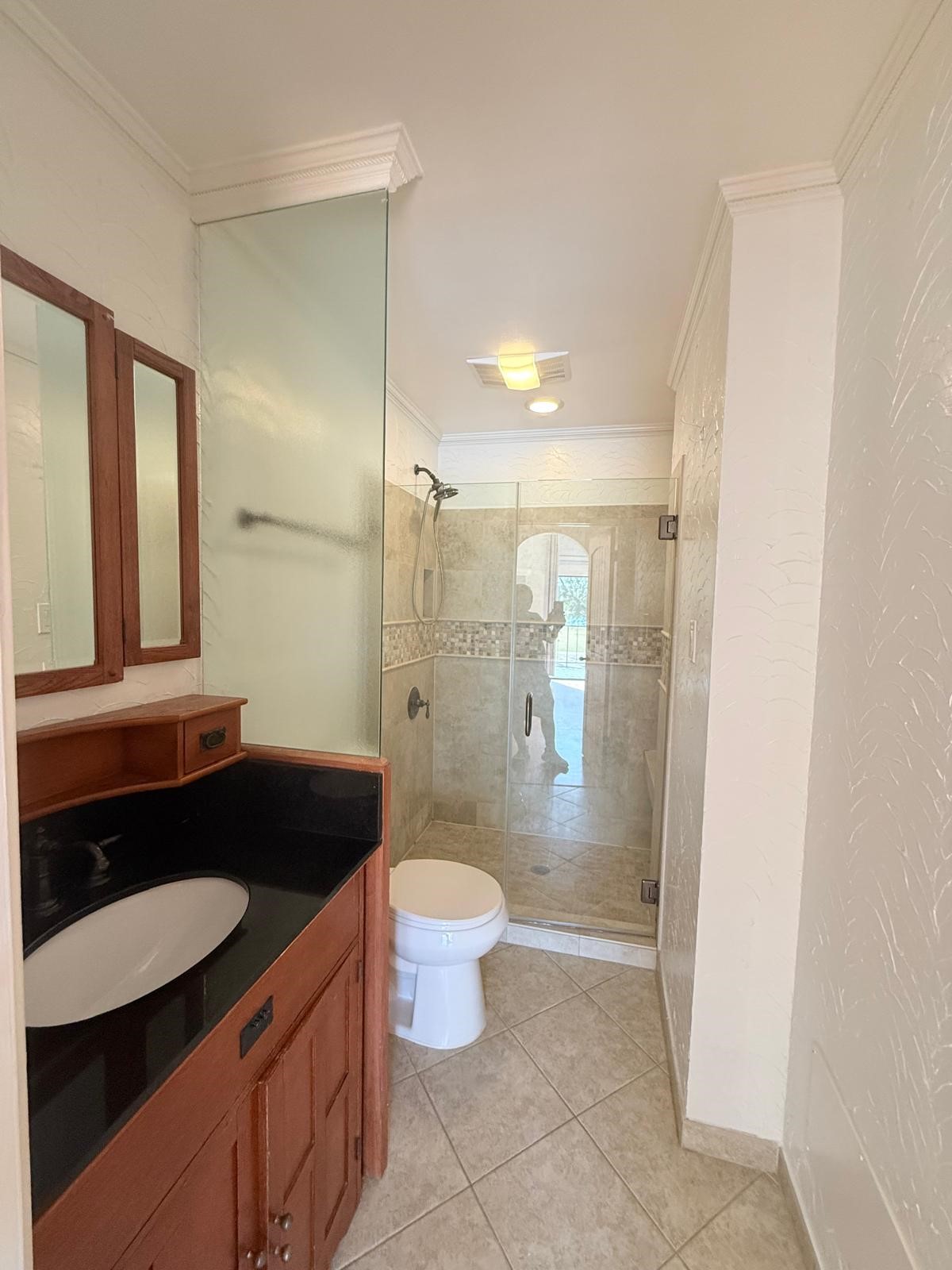 8287 Sands Point Drive, Unit 128 Houston, TX 77036 - Photo 19 of 30 a bathroom with a granite countertop sink a toilet a mirror and shower