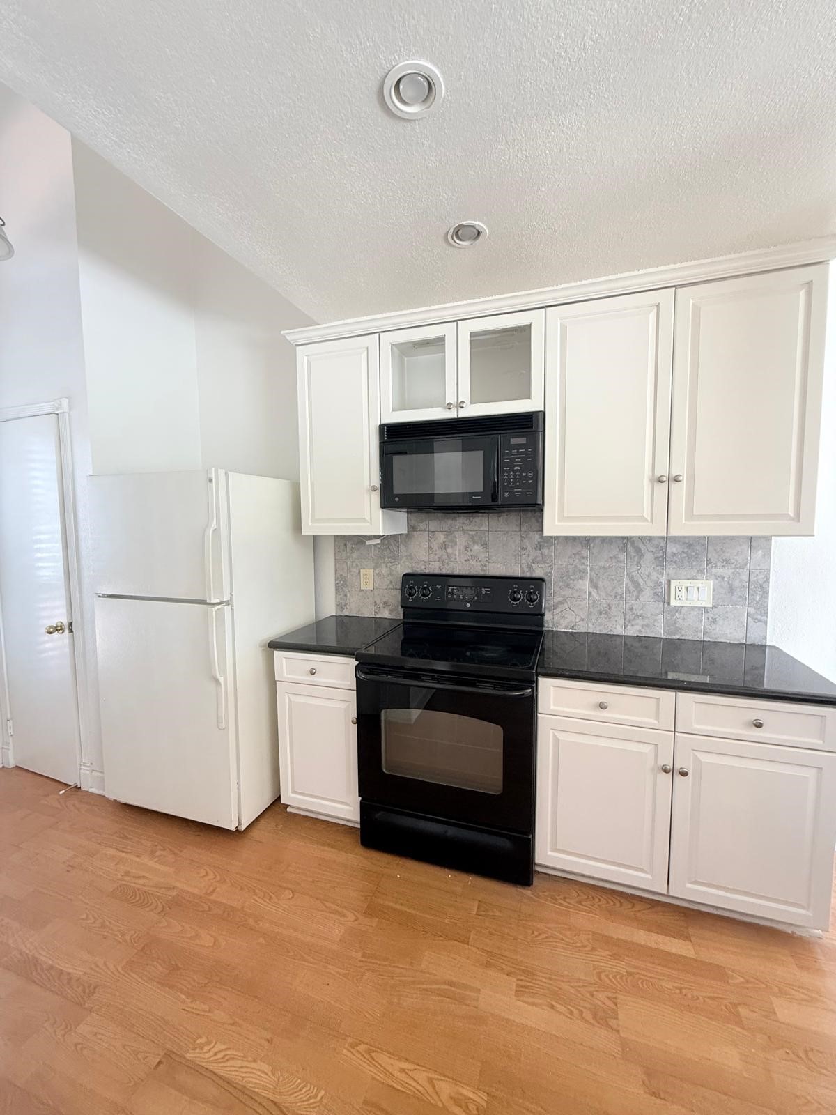 8287 Sands Point Drive, Unit 128 Houston, TX 77036 - Photo 8 of 30 a kitchen with a stove top oven and cabinets