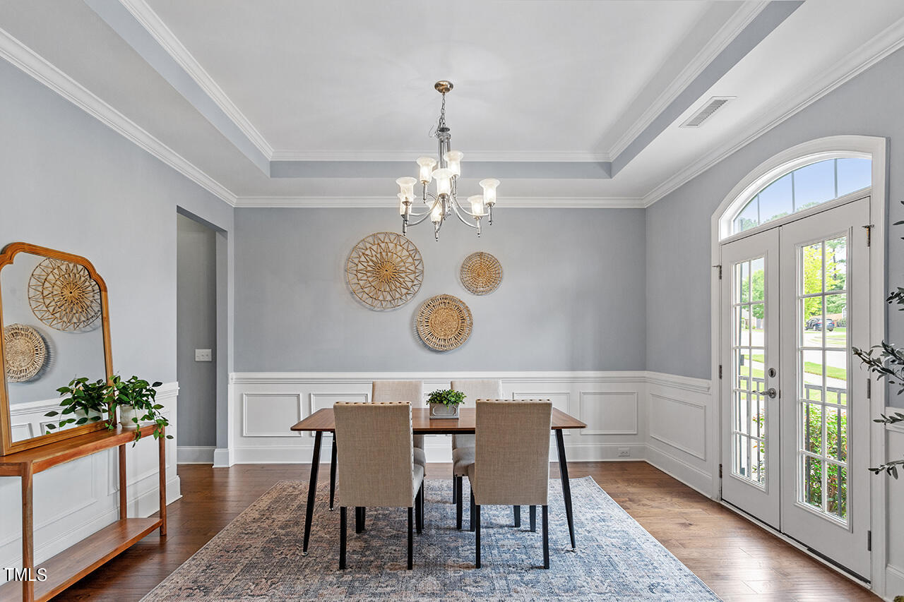 5273 Aleppo Lane Raleigh, NC 27613 - Photo 11 of 56 a view of a dining room with furniture a chandelier and wooden floor