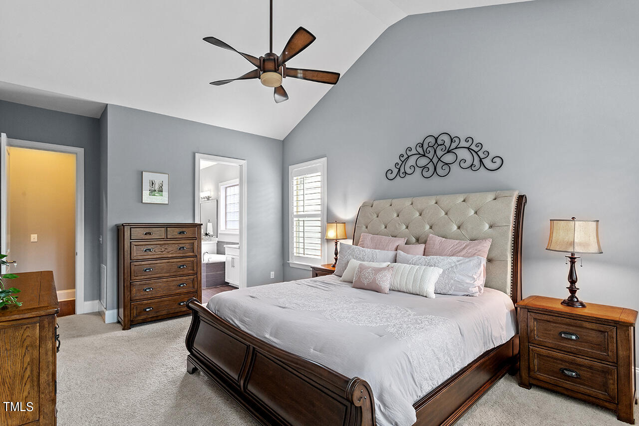 5273 Aleppo Lane Raleigh, NC 27613 - Photo 30 of 56 a bedroom with a bed and a chandelier