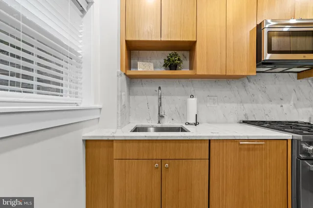 a kitchen with stainless steel appliances granite countertop a sink stove and microwave