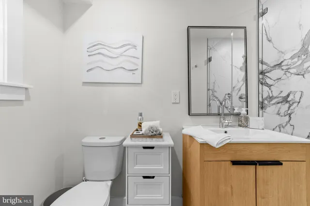 a bathroom with a sink mirror vanity and toilet