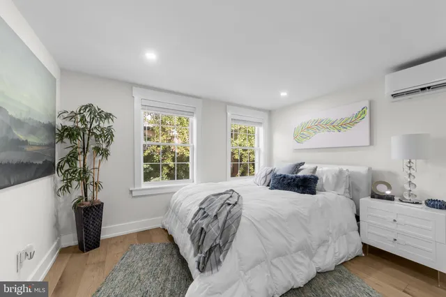 a bedroom with a large bed and a potted plant