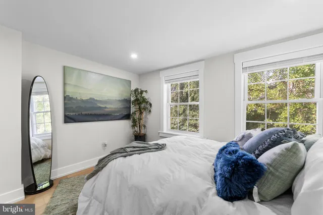 a spacious bedroom with a bed and a flat screen tv