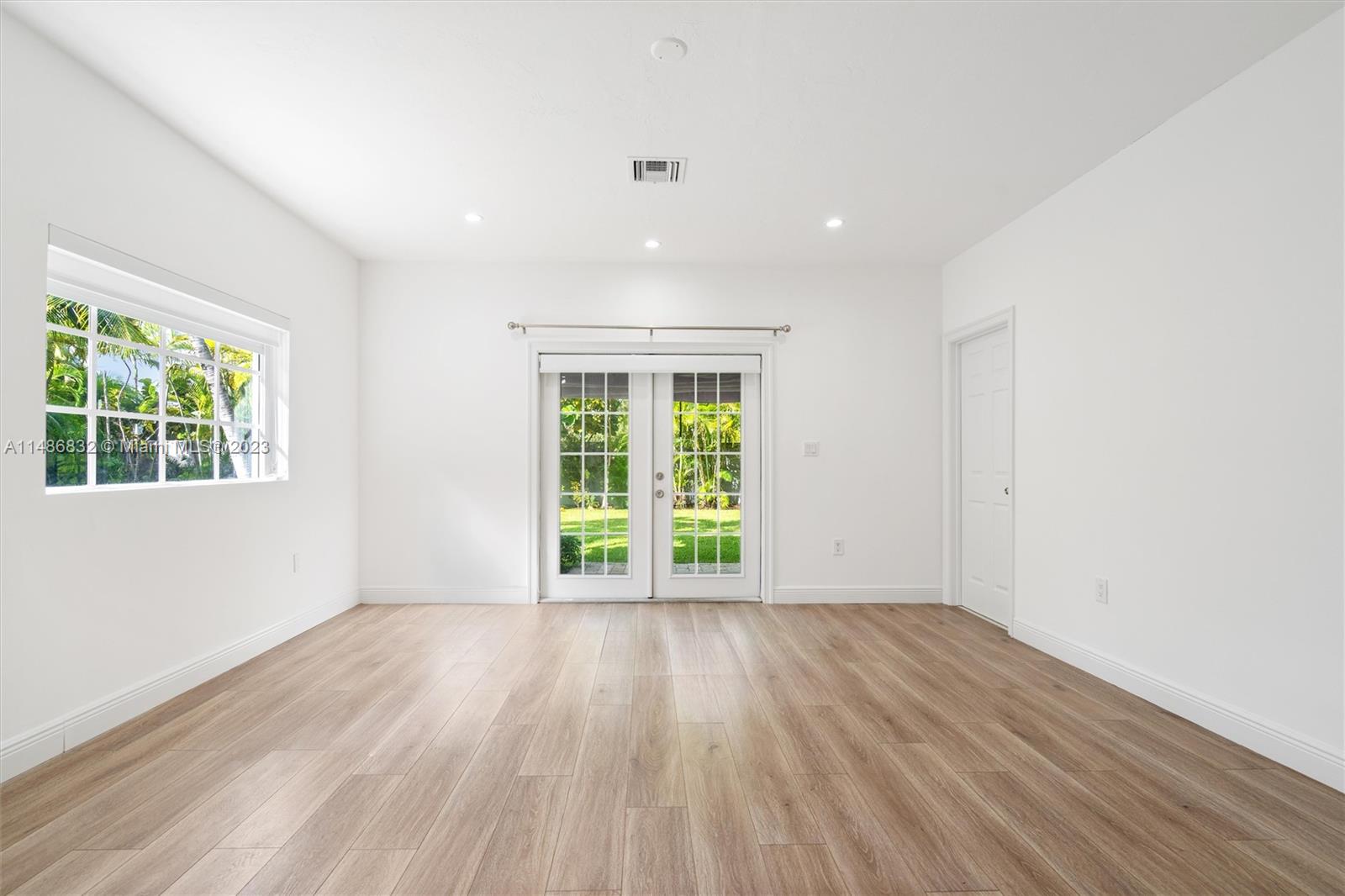 4160 Bay Point Road Miami, FL 33137 - Photo 9 of 27 a view of an empty room with wooden floor and a window