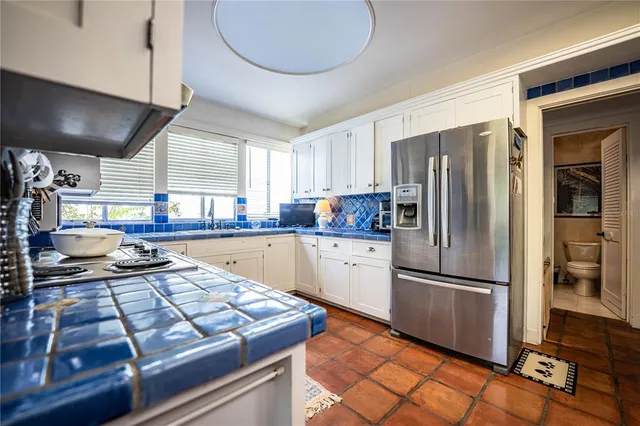 a kitchen with stainless steel appliances granite countertop a refrigerator and a stove