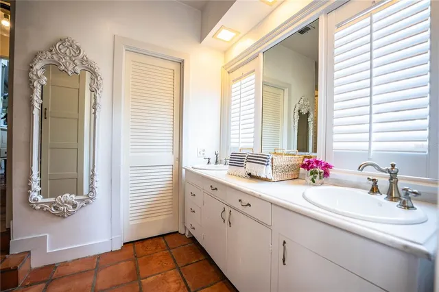 a bedroom with a bed a chandelier and dresser