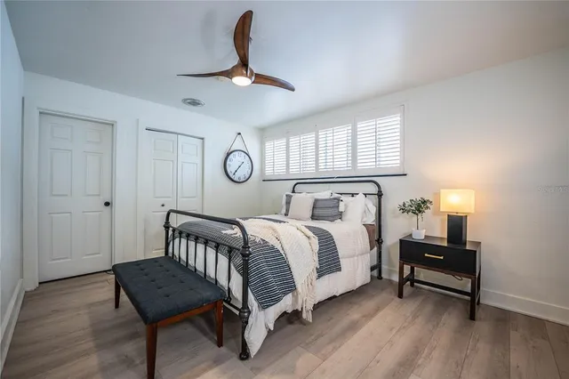 a bedroom with a bed and a lamp on dresser