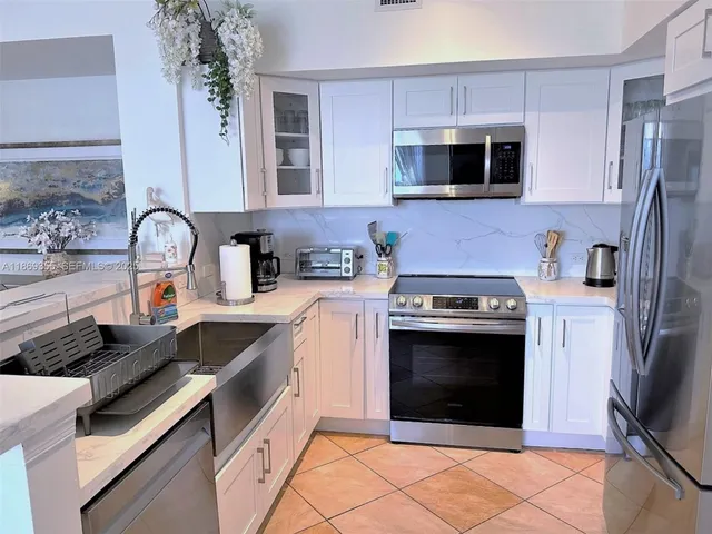 a kitchen with stainless steel appliances granite countertop a stove microwave and sink