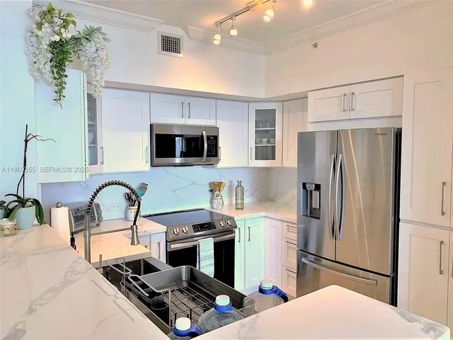 a kitchen with stainless steel appliances granite countertop a refrigerator sink and microwave