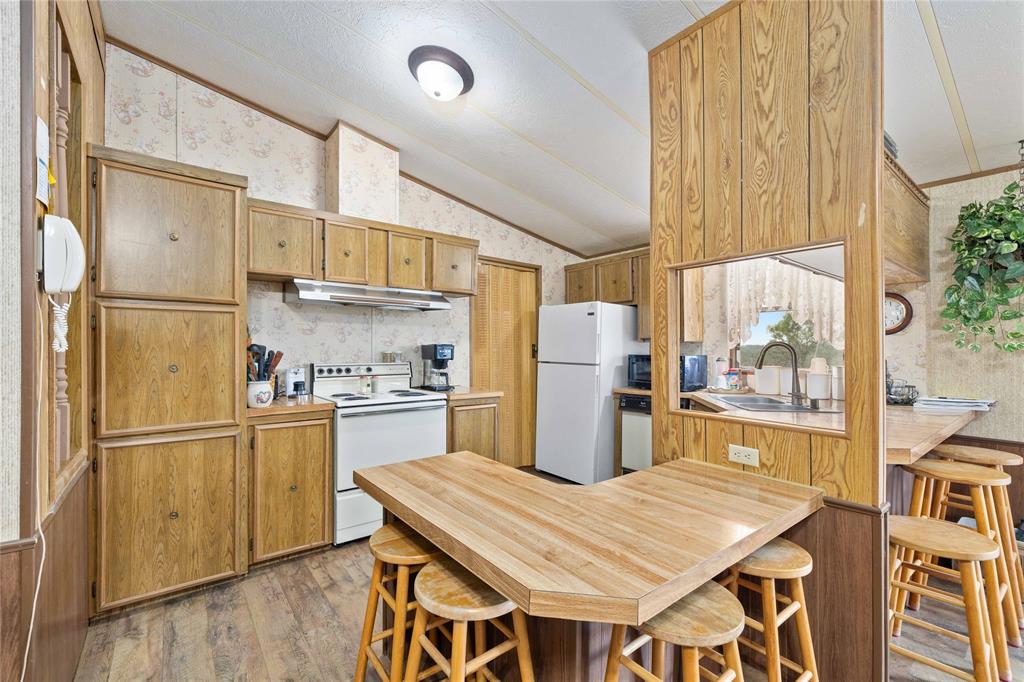 11814 County Road 266 Rochelle, TX 76872 - Photo 24 of 40 a kitchen with refrigerator and wooden cabinets