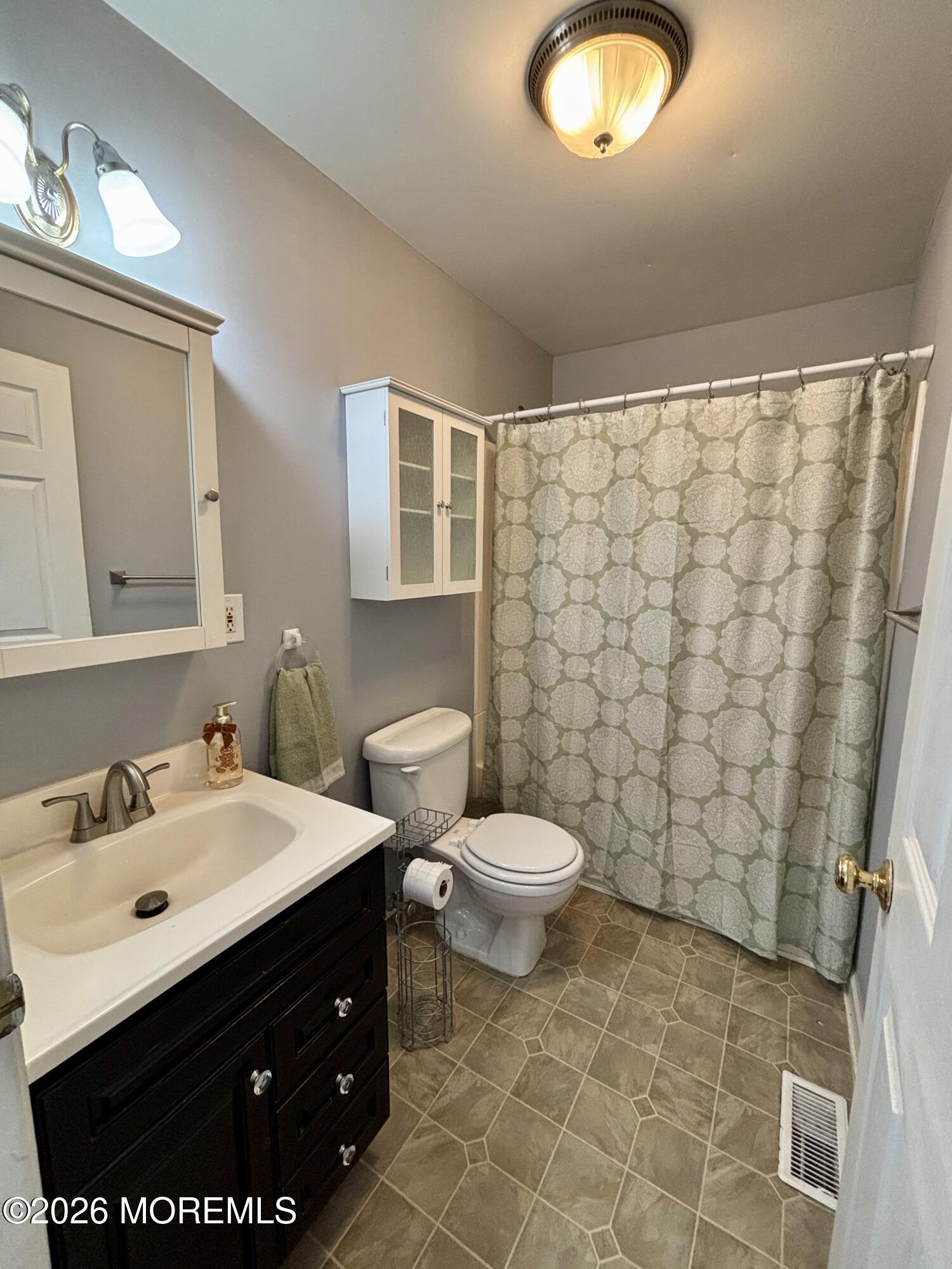 159 Bridge Avenue, Unit 1 Red Bank, NJ 07701 - Photo 4 of 22 a bathroom with a sink toilet and a mirror