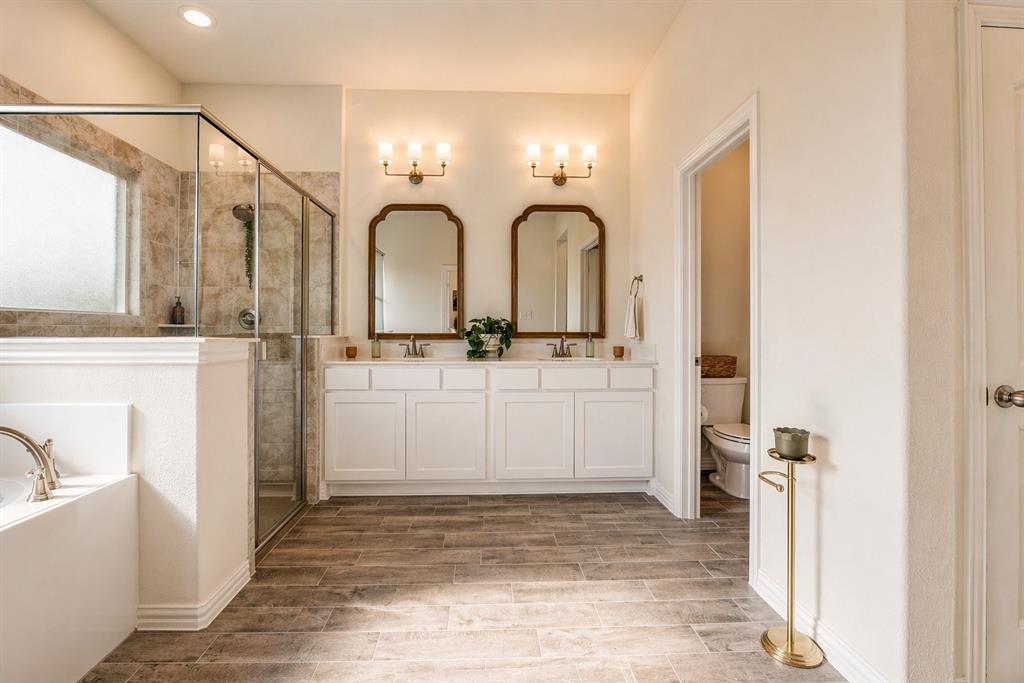 1530 County Road 200 Valley View, TX 76272 - Photo 21 of 34 Bathroom featuring wood-finish tile flooring, a built-in soaking tub, and a separate glass-enclosed shower with tile surround