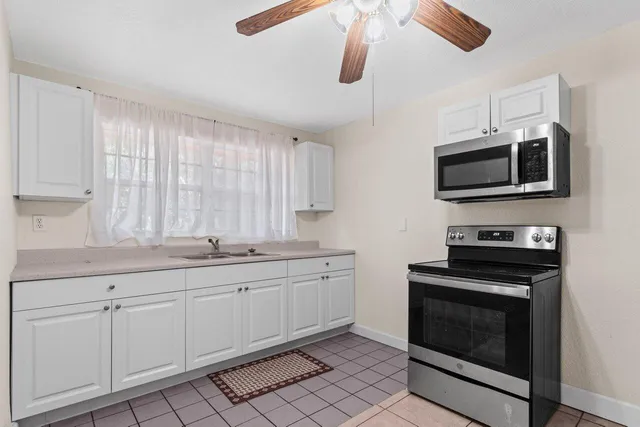 an aerial view of residential house with outdoor space and trees all around