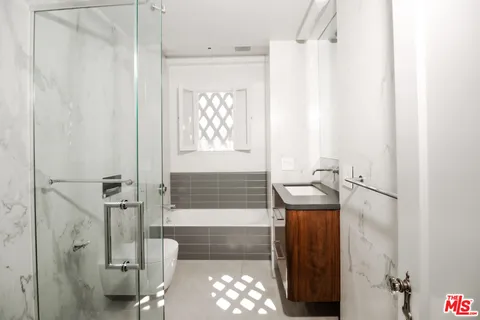 a bathroom with a granite countertop sink a toilet and shower