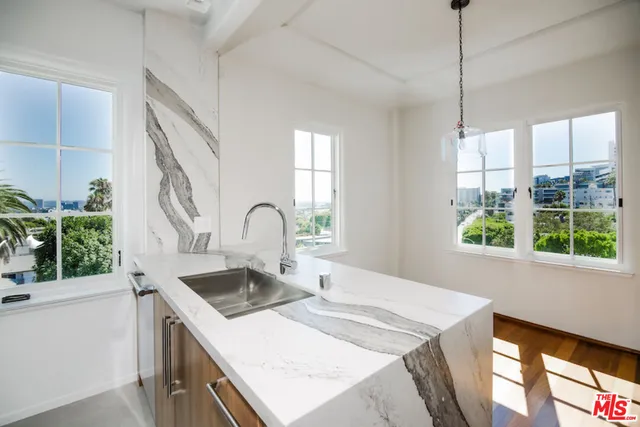 a kitchen that has a sink a stove and a wooden floor
