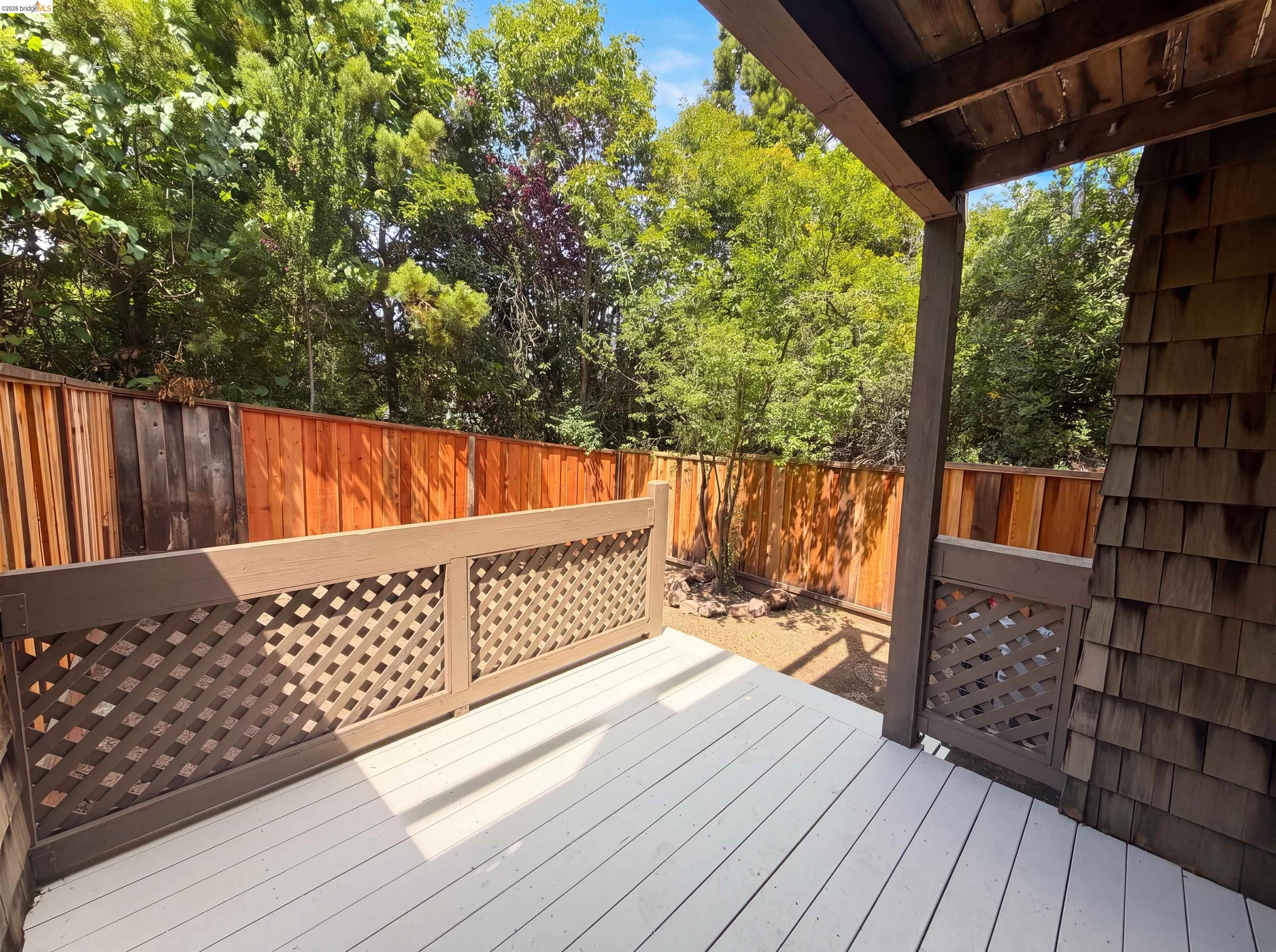 1555 Hecker Pass Road, Unit C101 Gilroy, CA 95020 - Photo 16 of 18 Outdoor deck featuring a painted floor, lattice railing, and shingle siding