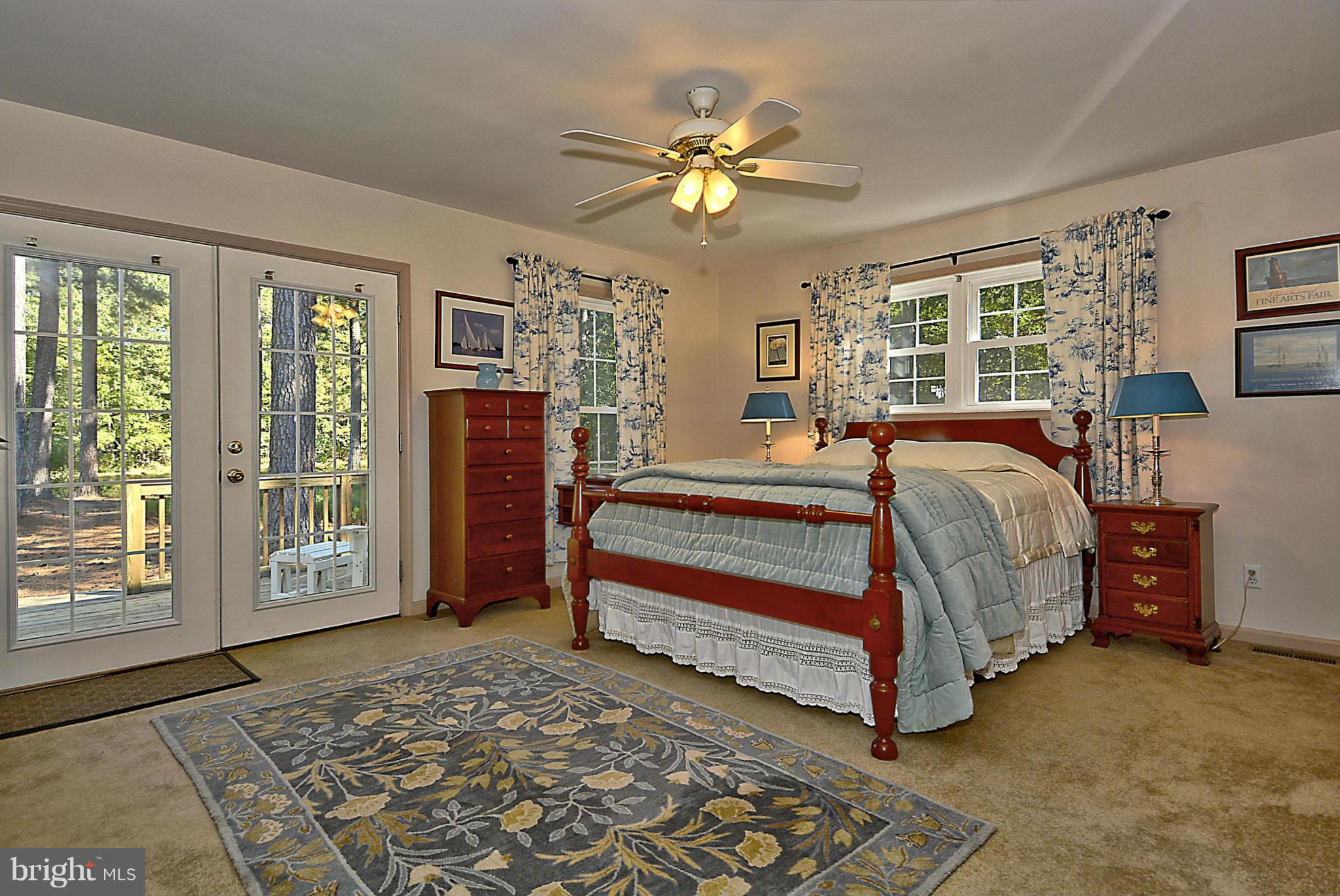 24100 Forest Pond Road St. Michaels, MD 21663 - Photo 14 of 20 a bedroom with a large bed and a chandelier