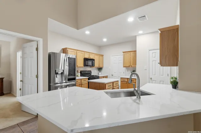 a large white kitchen with a large window and stainless steel appliances