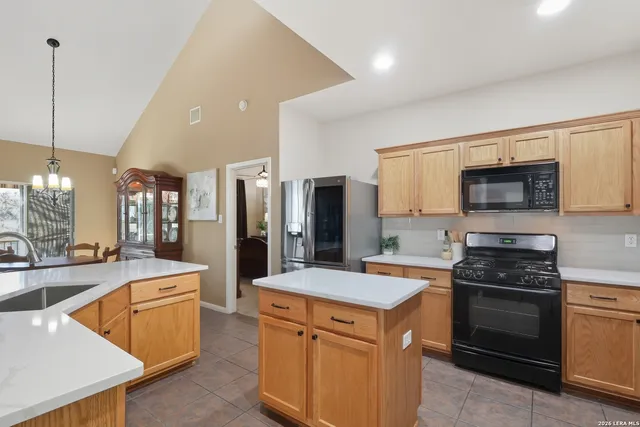 a kitchen with stainless steel appliances kitchen island granite countertop a refrigerator stove and sink