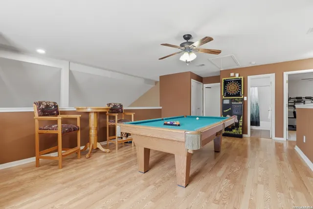 a room with furniture a wooden floor and a ceiling fan