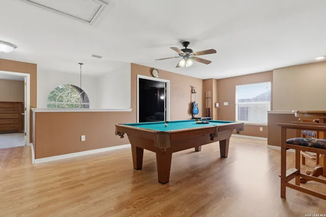 a room with pool table and windows