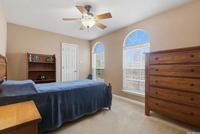 a bedroom with a bed and a ceiling fan